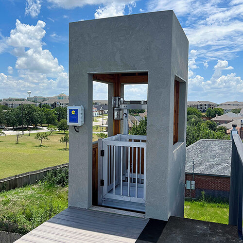 Galaxy Shuttle cargo lift on a stucco rooftop tower under a blue sky