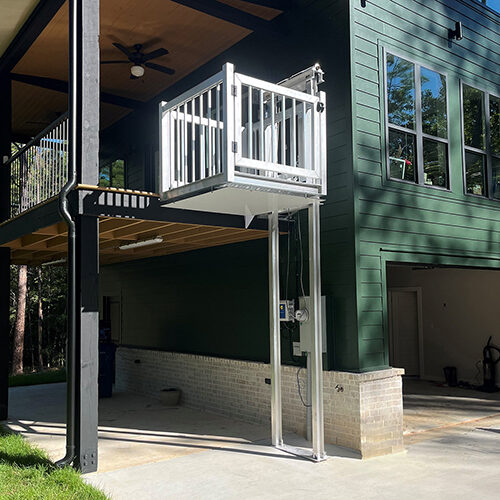 Galaxy Shuttle+ cargo lift on a deep green board-and-batten home