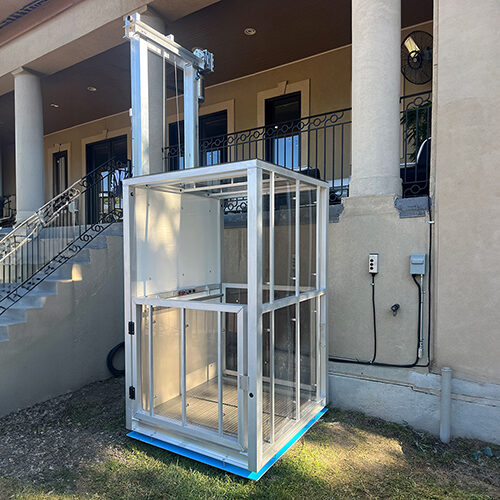 Galaxy Traveler passenger lift on a tan stucco house with an iron stair railing