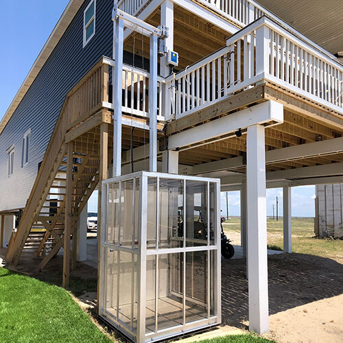 Galaxy Traveler passenger lift on a blue-and-white coastal stilt home