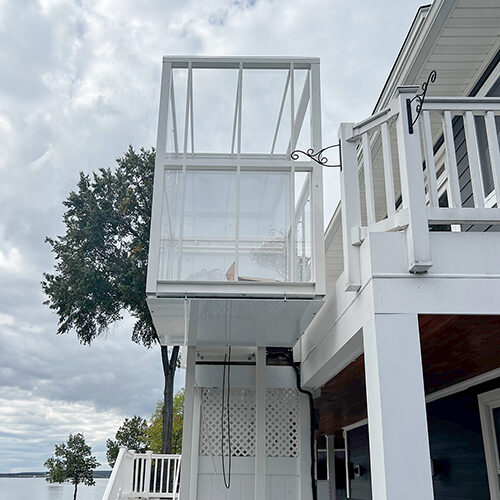 Galaxy Traveler passenger lift on a white-shingle home under overcast light